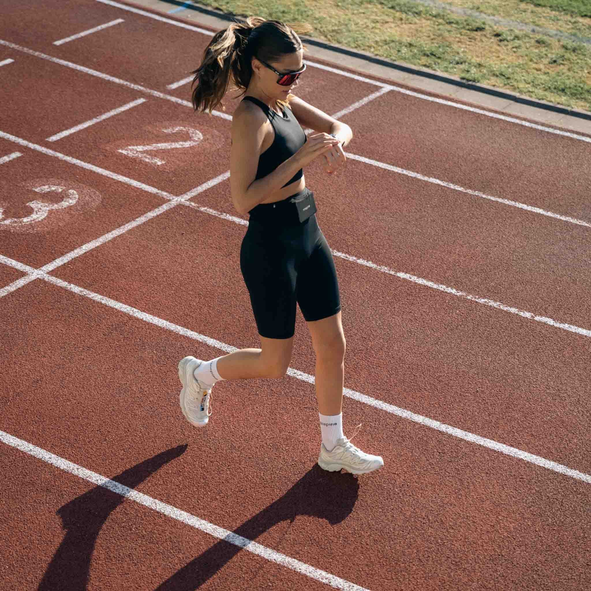 Girl running on track with ninepine outfit